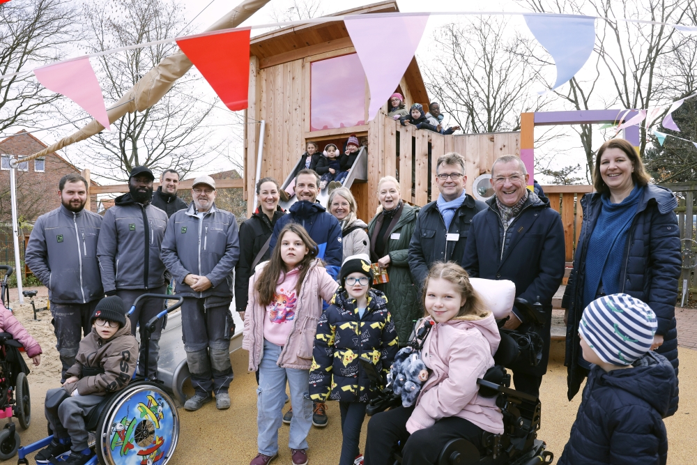 ChatGPT:  Feier zur Eröffnung des neuen inklusiven Spielplatzes der Mira Lobe Schule: Förderer, Schulleitung und weitere Beteiligte stehen zusammen mit vielen Kindern mit und ohne Behinderung auf dem Schulhof. Die Atmosphäre ist fröhlich, es wird gelacht, gesprochen und gemeinsam gefeiert.