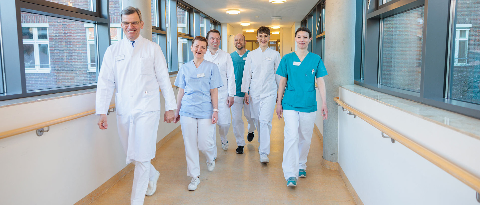 Mehrere Personen aus dem Team der Unfallchirurgie gehen über einen Krankenhausflur